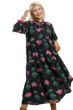 Woman wearing a black dress with colorful floral pattern on a white background