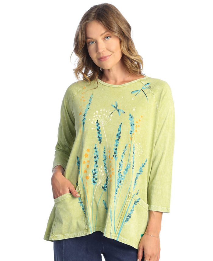 Woman wearing a light green blouse with floral designs on a white background