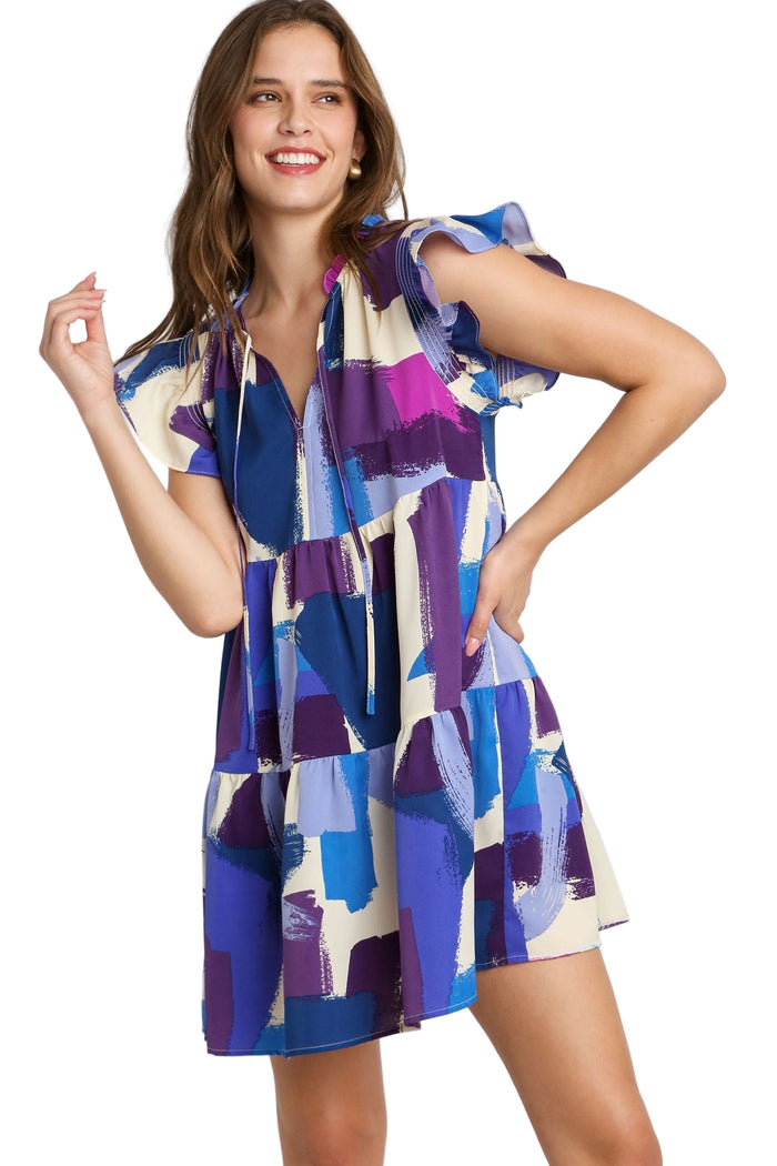Woman wearing a colorful patterned dress on a plain background