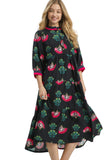 Woman wearing a black dress with colorful floral patterns on a white background