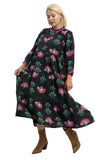 Woman wearing a black dress with pink and green floral patterns on a white background