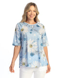 Woman wearing a blue floral print top on a white background