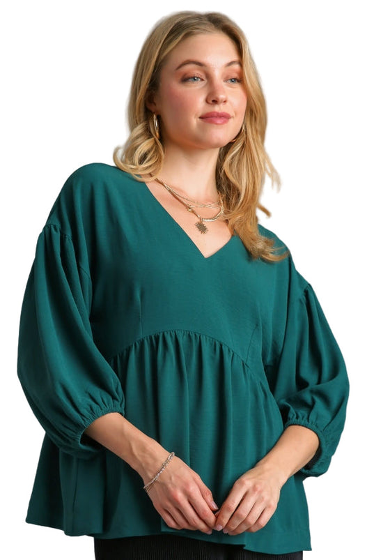 Woman wearing a green blouse against a gray background