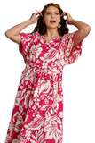 Woman wearing a pink and white floral dress on a gray background
