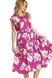 Woman wearing a pink floral dress on a gray background