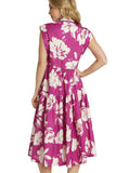 Woman wearing a raspberry pink dress with white floral pattern on a plain background