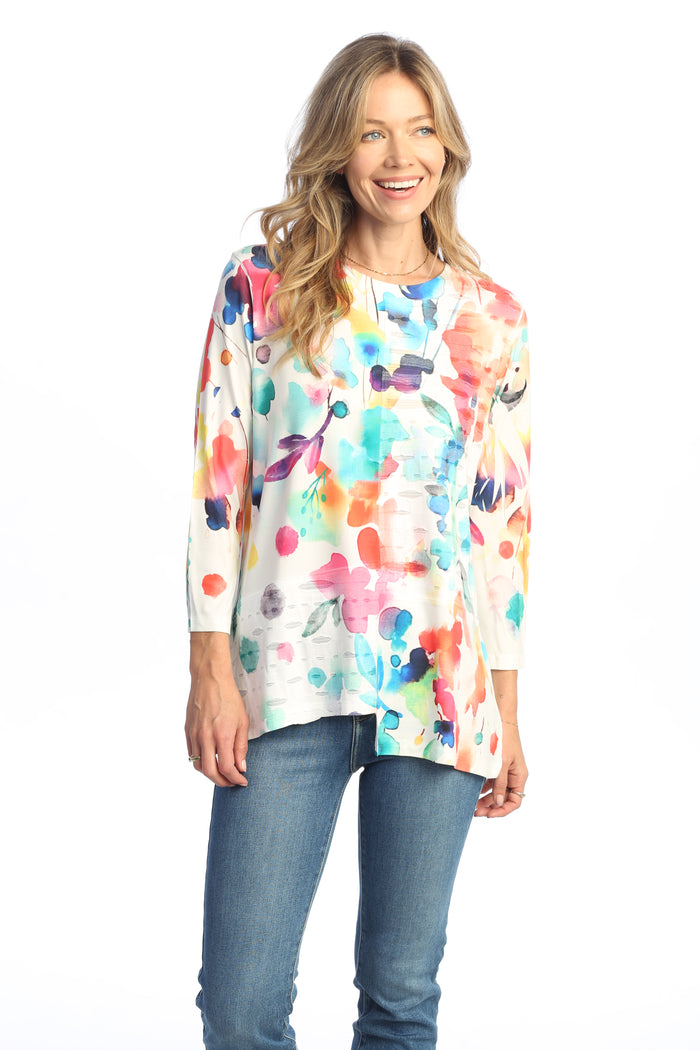 Woman wearing a colorful floral top with a white background