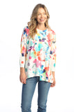 Woman wearing a colorful floral top with a white background