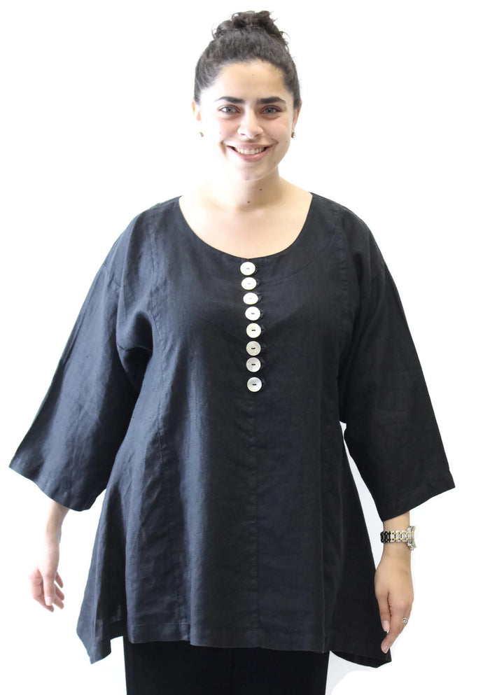 Woman wearing a black tunic with button details on a white background