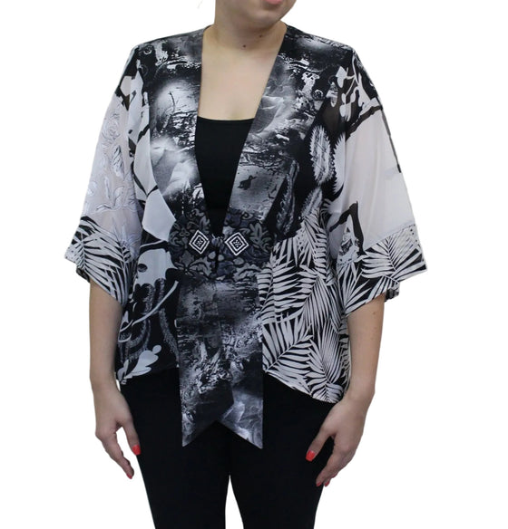 Person wearing a black and white patterned kimono-style top against a plain background