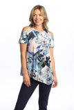 Woman wearing a floral blouse and dark pants on a white background
