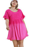 Woman wearing a pink dress with ruffled sleeves on a white background