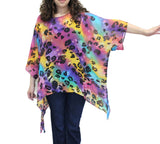 Person wearing a colorful leopard print poncho on a white background
